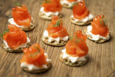 Smoked Trout Blinis on a wooden board clipart
