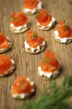 Alabalık kanepeler ahşap bir masa üzerinde füme