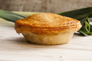 Pişmiş pasta ve pürüzsüz bir ahşap yüzey üzerinde pırasa