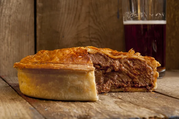 Pastel de carne con rebanada faltante con cerveza — Foto de Stock