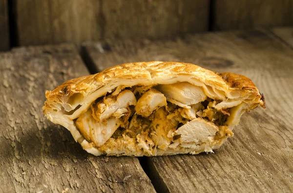 Meia torta de frango em fundo de madeira — Fotografia de Stock