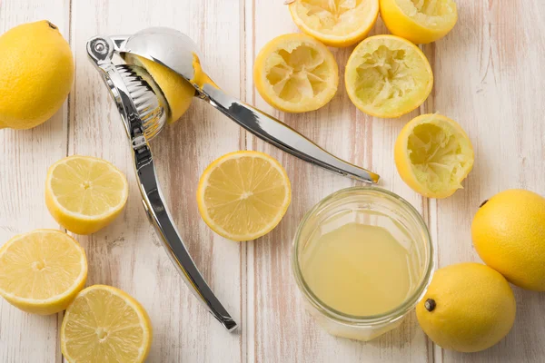 Citroen pers met citroenen en het SAP in glas — Stockfoto