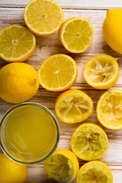 Lemon Juice in Glass Alalongside Lemons — стоковое фото