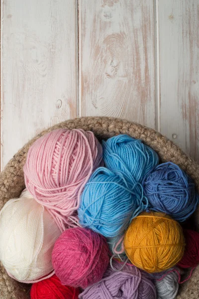 Balls of Colour Wool in Bowl on Wooden Background