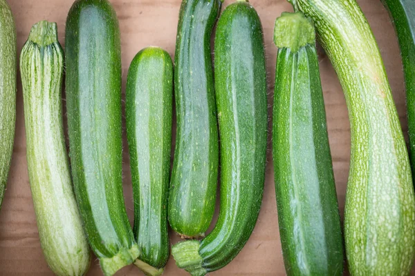 Reihe von Zucchini auf hellem Holzhintergrund — Stockfoto