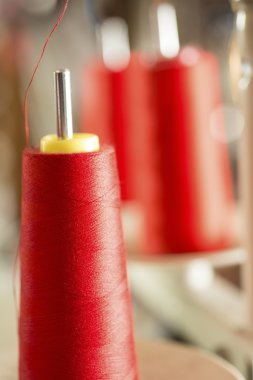 Makine iğne üzerinde kırmızı iplik makarası