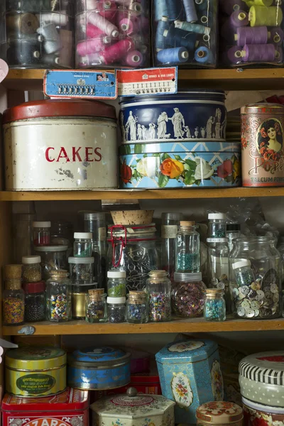 Blikjes en potten van wol, kralen en knopen — Stockfoto