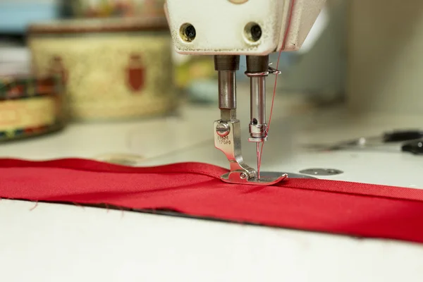 Швейная машина игла Привязывание красной атласной ленты к ткани — стоковое фото