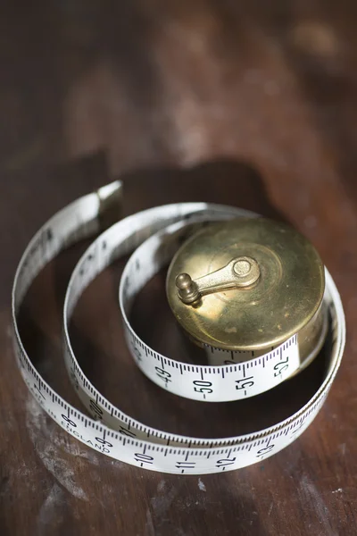 Rolled Measuring Tape on Hardwood Surface — Φωτογραφία Αρχείου