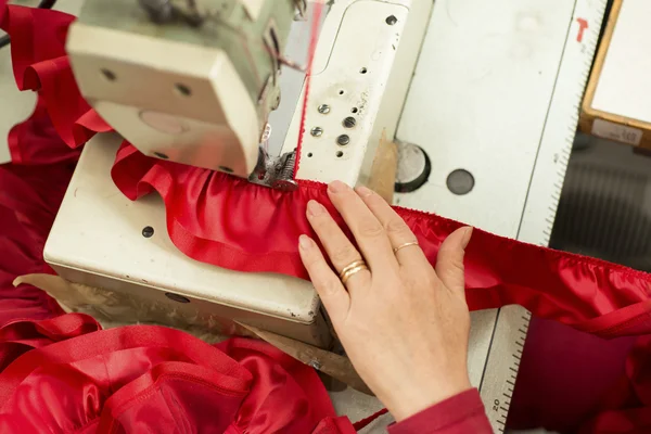 Hand on Sewing Machine Stitching Red Ribbon and Ruffled Cloth — Stock Photo, Image