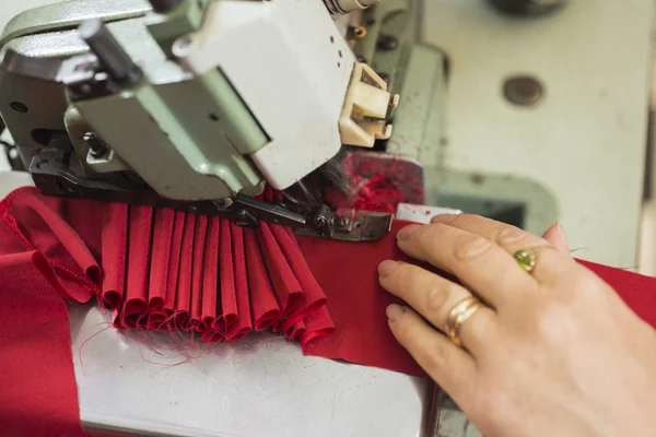 Lady sarto mani cucitura panno rosso sulla macchina da cucire — Foto Stock