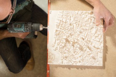 Bir adam bir alçı Model matkap ile Perfore havai görünümü