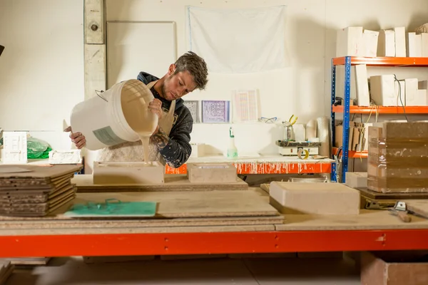 Man despejando mistura de gesso no molde — Fotografia de Stock