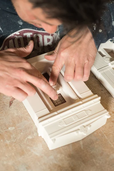 Man steekt een venster op een schaal Model gebouwen — Stockfoto