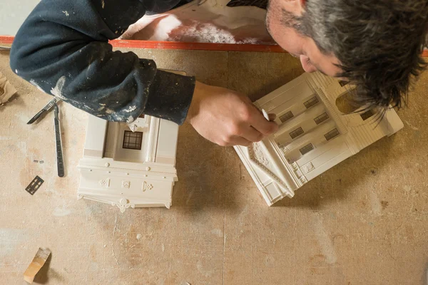 Homem fazendo toques de acabamento para um modelo de construção de escala — Fotografia de Stock