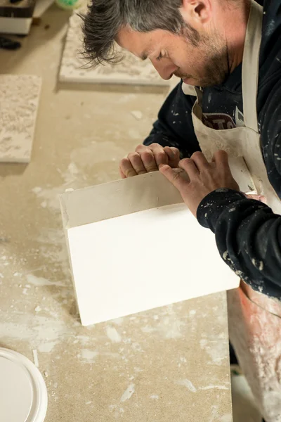 Trabalhador tentando separar um modelo de gesso do molde — Fotografia de Stock