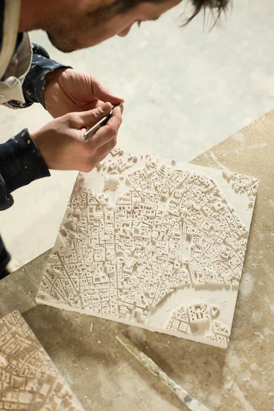 Homem trabalhando no componente minúsculo do modelo 3D do mapa da cidade — Fotografia de Stock