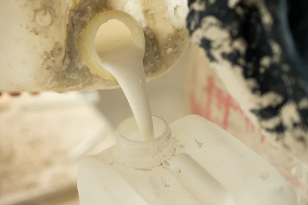 Resina de gesso líquido derramando em um grande jarro de plástico — Fotografia de Stock
