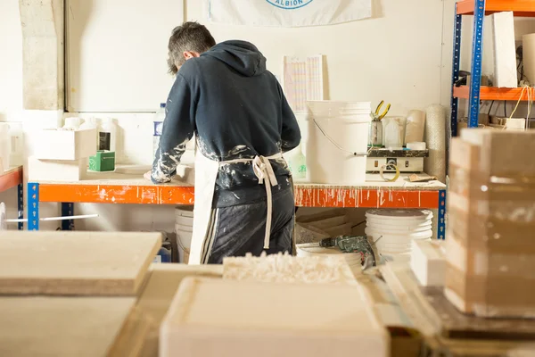 Lavoratore con la schiena girata Lavorando da un tavolo enorme — Foto Stock