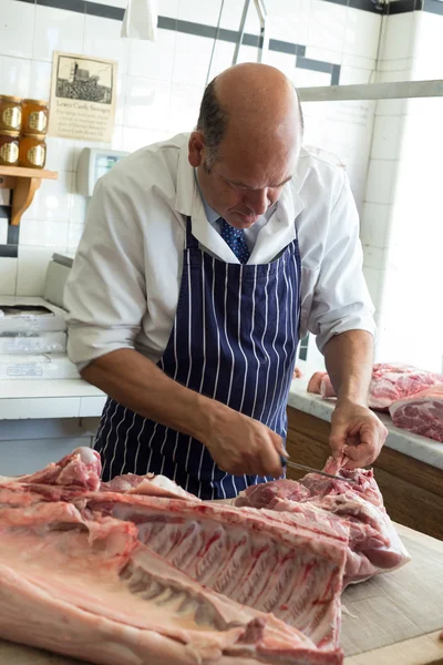 Açougueiro Cortar a gordura em uma junta de carne — Fotografia de Stock