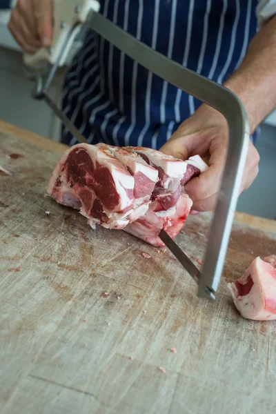 Butchering a joint with large saw — Stock Photo, Image