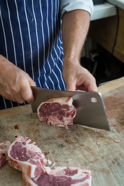 Butchering a joint of lamb with large cleaver — Stock Photo, Image