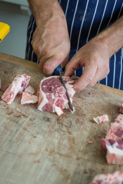 Preparing raw joint with a sharp knife — Stock Photo, Image