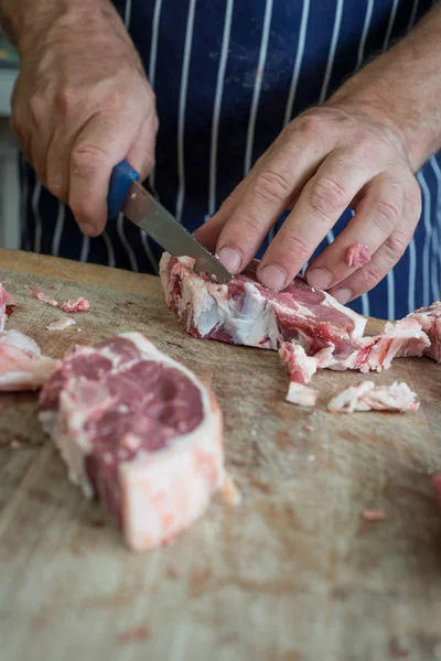 Cutting raw meat with a sharp knife — Stock Photo, Image