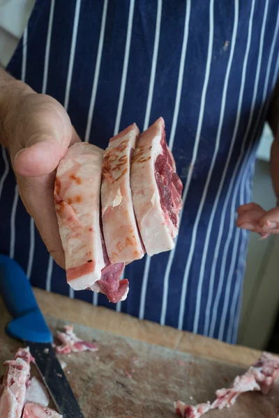 Butcher holding raw meat steaks — Stock Photo, Image