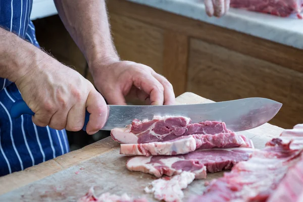 Butchering a joint with large knife — Stock Photo, Image