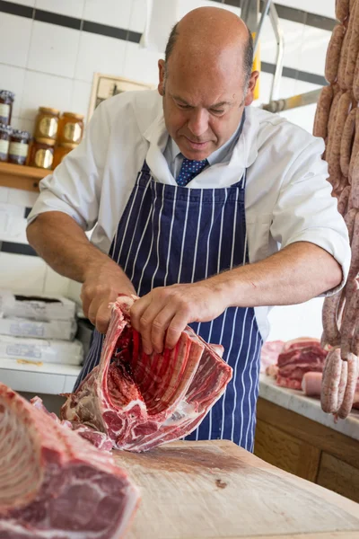 Carniceiro na loja a matar um cordeiro com as mãos — Fotografia de Stock