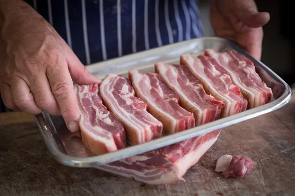 Butcher holding a Tray of pork belly — Stock Photo, Image