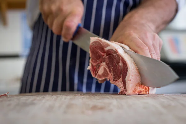 Close up of butcher carving raw lamb — Stock Photo, Image