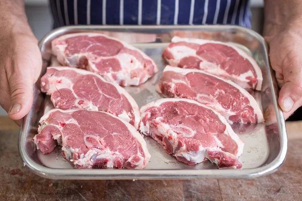 Hentes gazdaság egy tálca, bárány steak — Stock Fotó