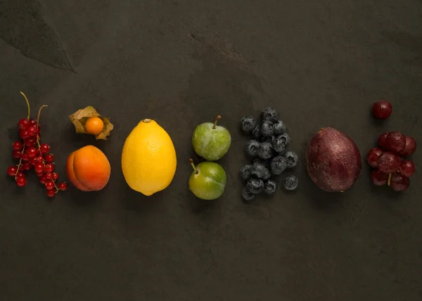 Wyciągam z kolorowych owoców na ciemnym tle — Zdjęcie stockowe