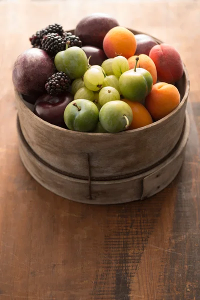 Kleurrijke Fruit in rustieke kom — Stockfoto