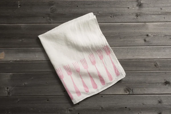 Serviette pliée avec motif de fourchette rose sur la surface en bois — Photo