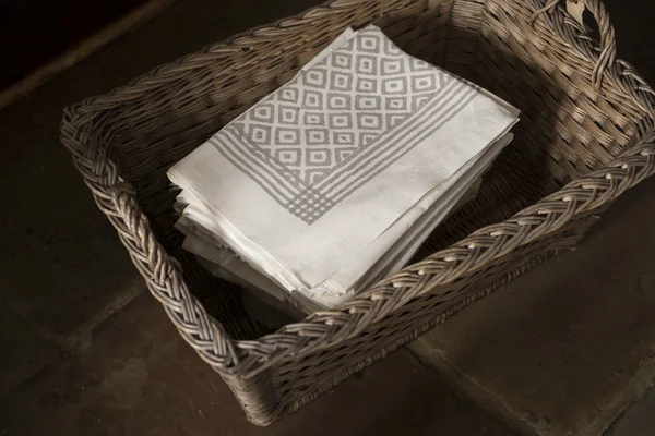 Pile de serviettes avec motif carré noir dans le panier tissé — Photo