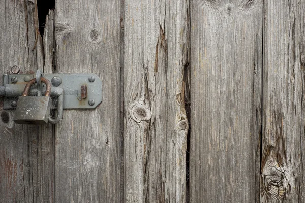 Velha porta de madeira com um cadeado — Fotografia de Stock