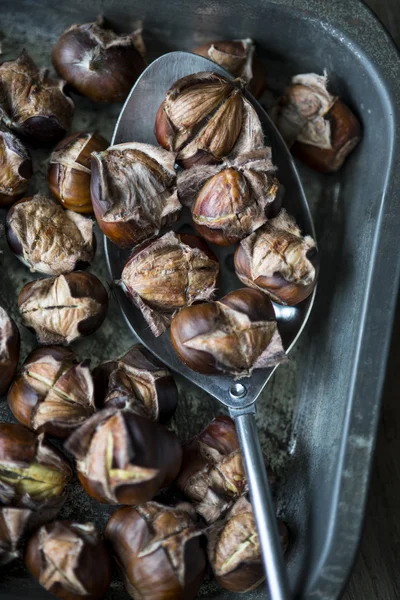 Castanhas assadas em uma colher de metal — Fotografia de Stock