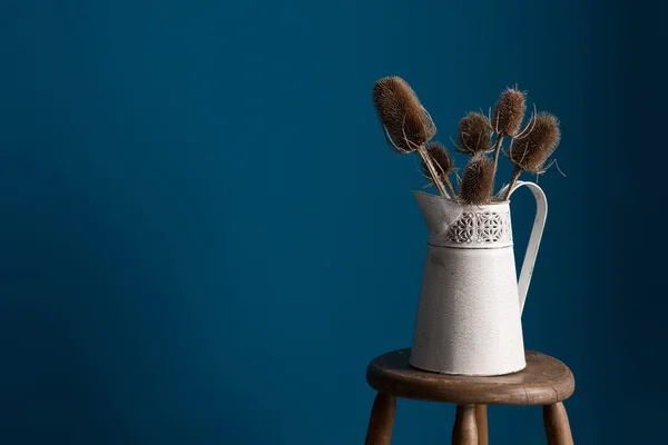 Vue grand angle du vieux vase avec chardons sur tabouret — Photo