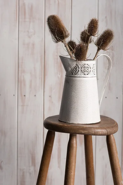 Gros plan du vase avec chardons sur tabouret sur fond en bois — Photo