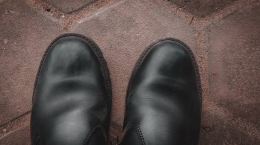 Kahverengi arka planda siyah deri ayakkabılar