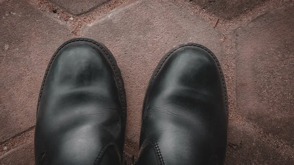 Kahverengi arka planda siyah deri ayakkabılar