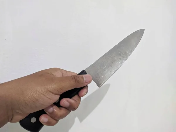 Elinde siyah bir bıçak tutan bir adam.