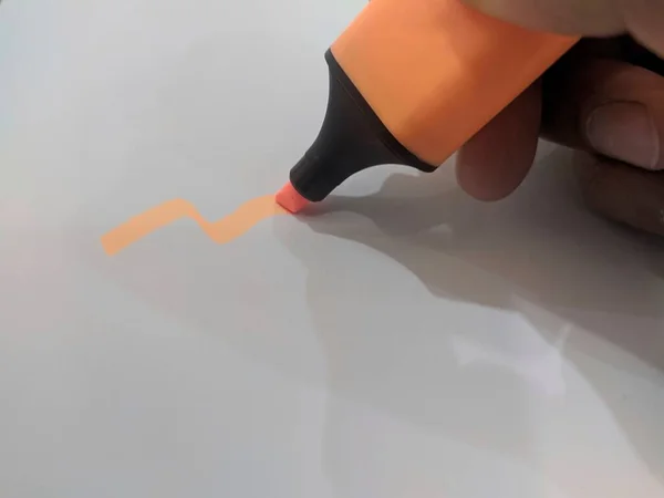 beyaz kağıt üzerinde turuncu kalem işareti