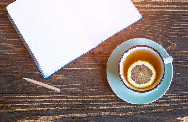 Hot tea with lemon and notebook — Stock Photo, Image