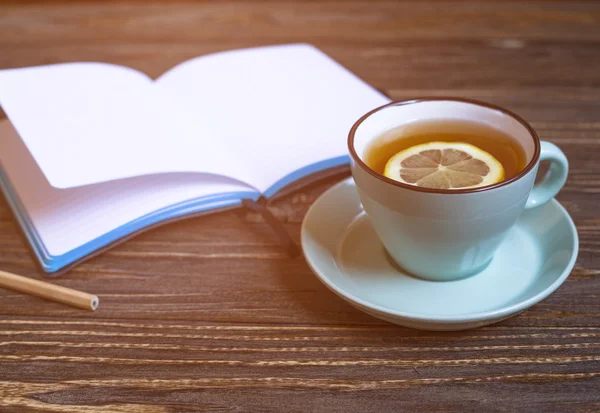 Té caliente con limón y cuaderno — Foto de Stock