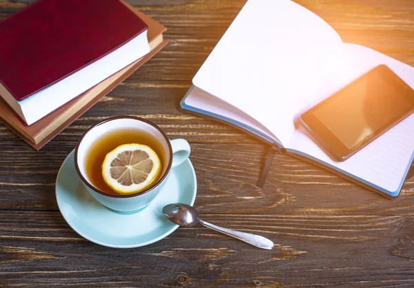 Hot tea with lemon and phone — Stock Photo, Image