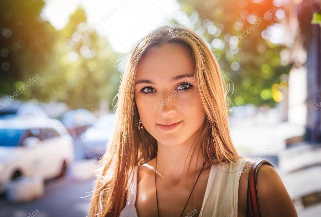 happy woman walking in the street and smiling to camera